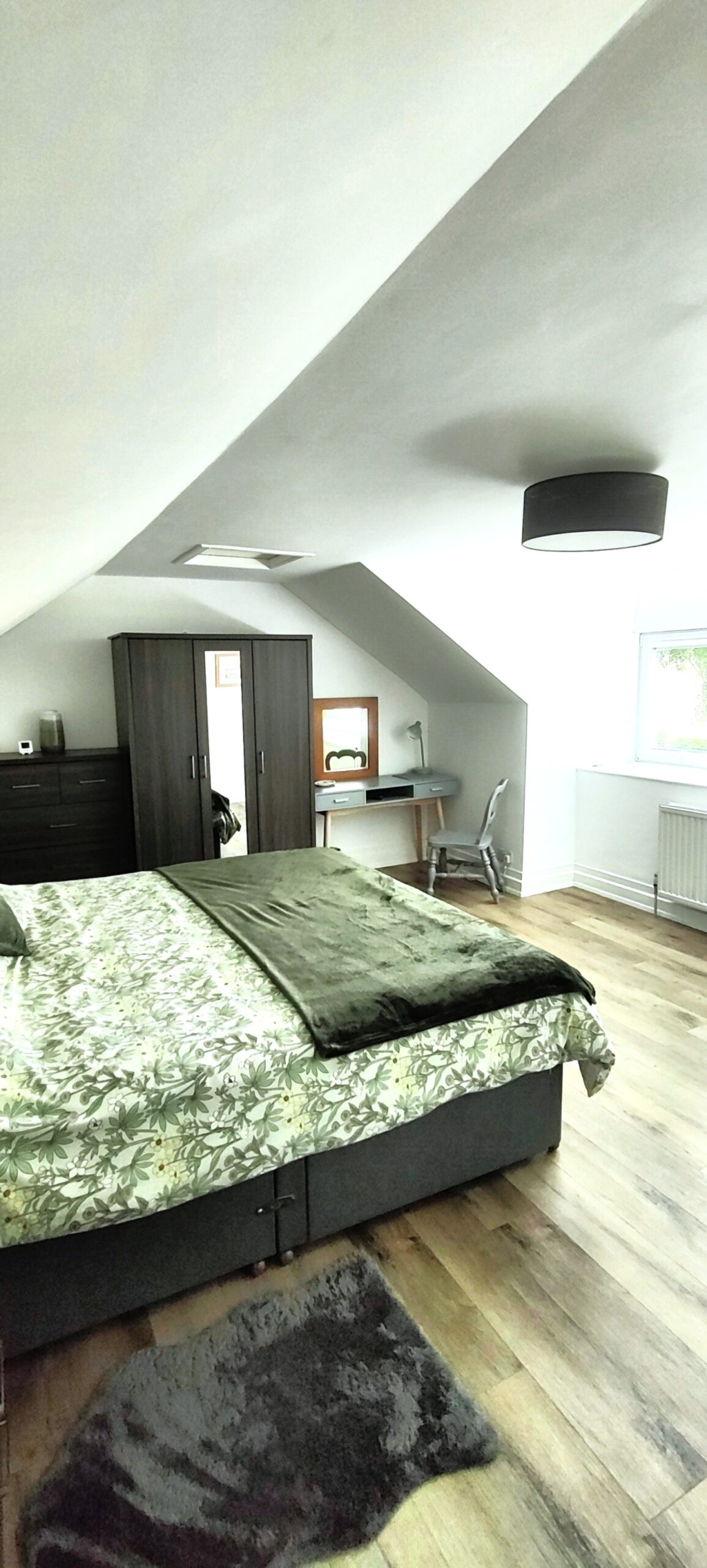 Bedroom showing bed, chest of draws, wardrobe, and dressing table